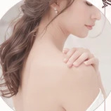 肩に手をあてて二の腕を気にしている女性